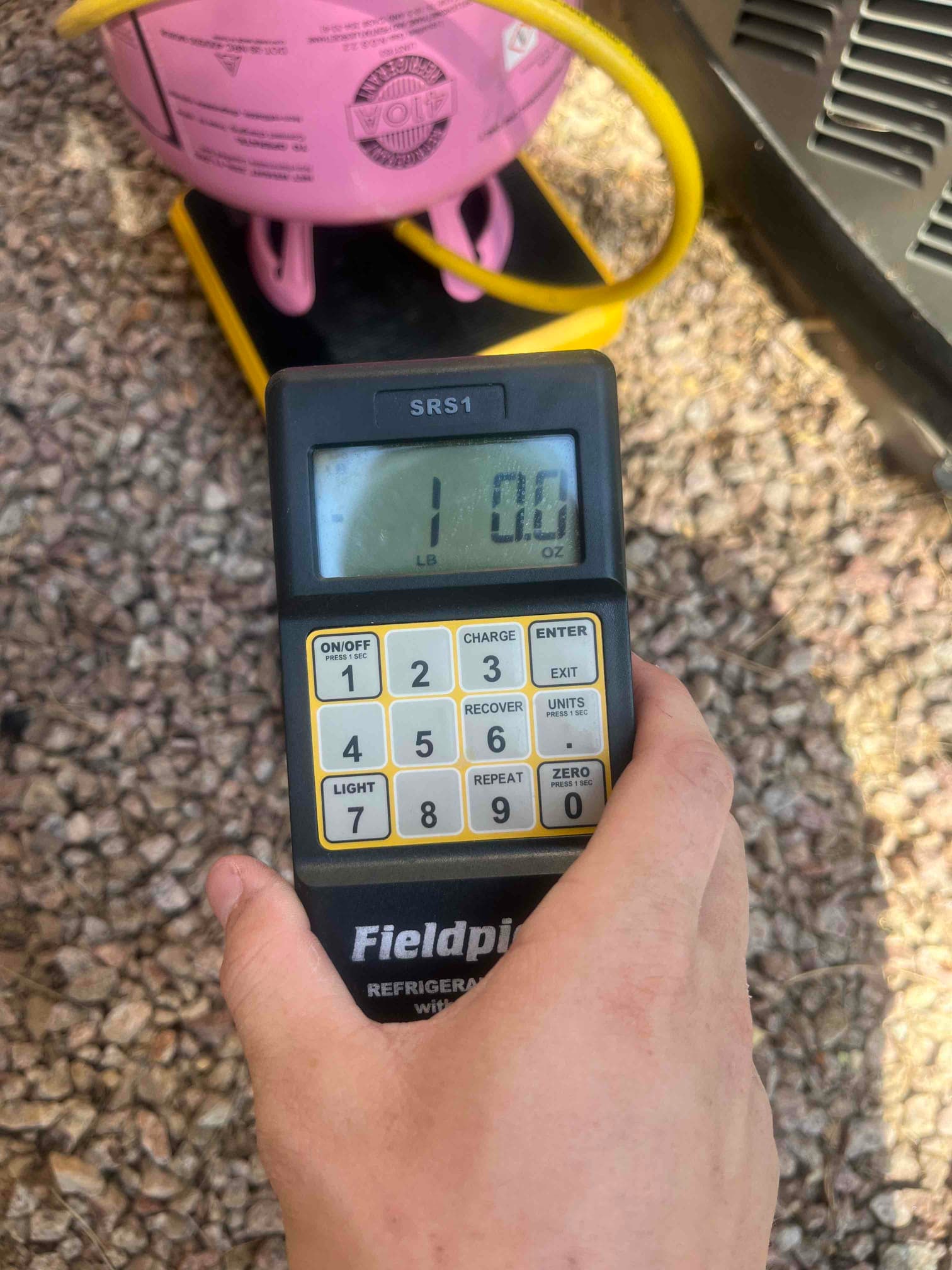 Refrigerant scale photographed during the service visit; no numerical reading is transcribed.