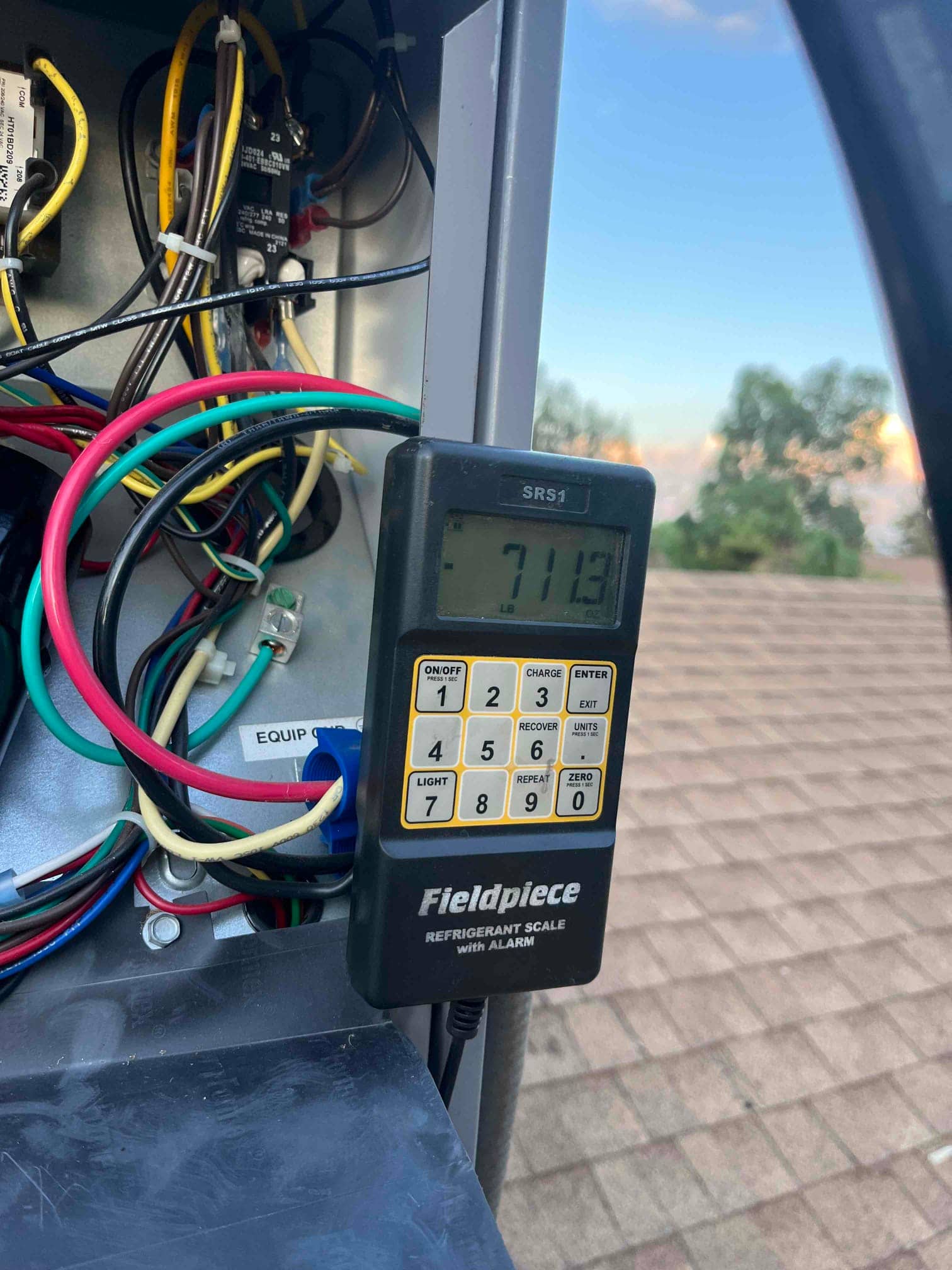 Refrigerant scale photographed during the service visit; no numerical reading is transcribed.