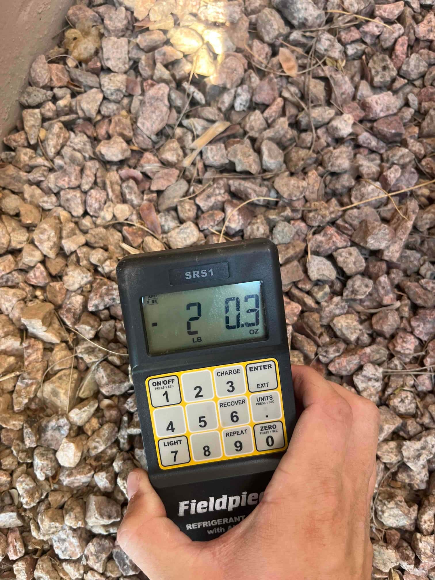 Refrigerant scale photographed during the service visit; no numerical reading is transcribed.
