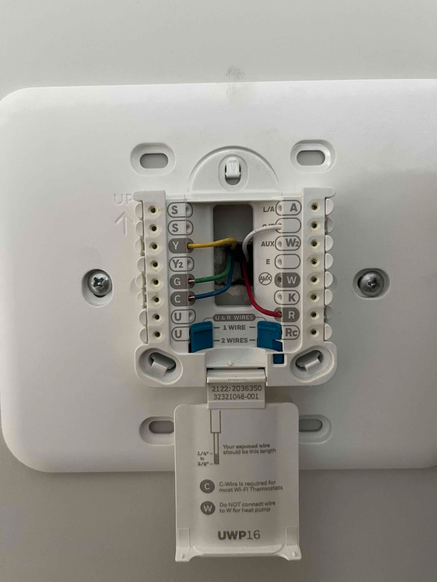 Thermostat base shows connected red, white, yellow, green, and blue conductors on labeled terminals, with the setup door open.