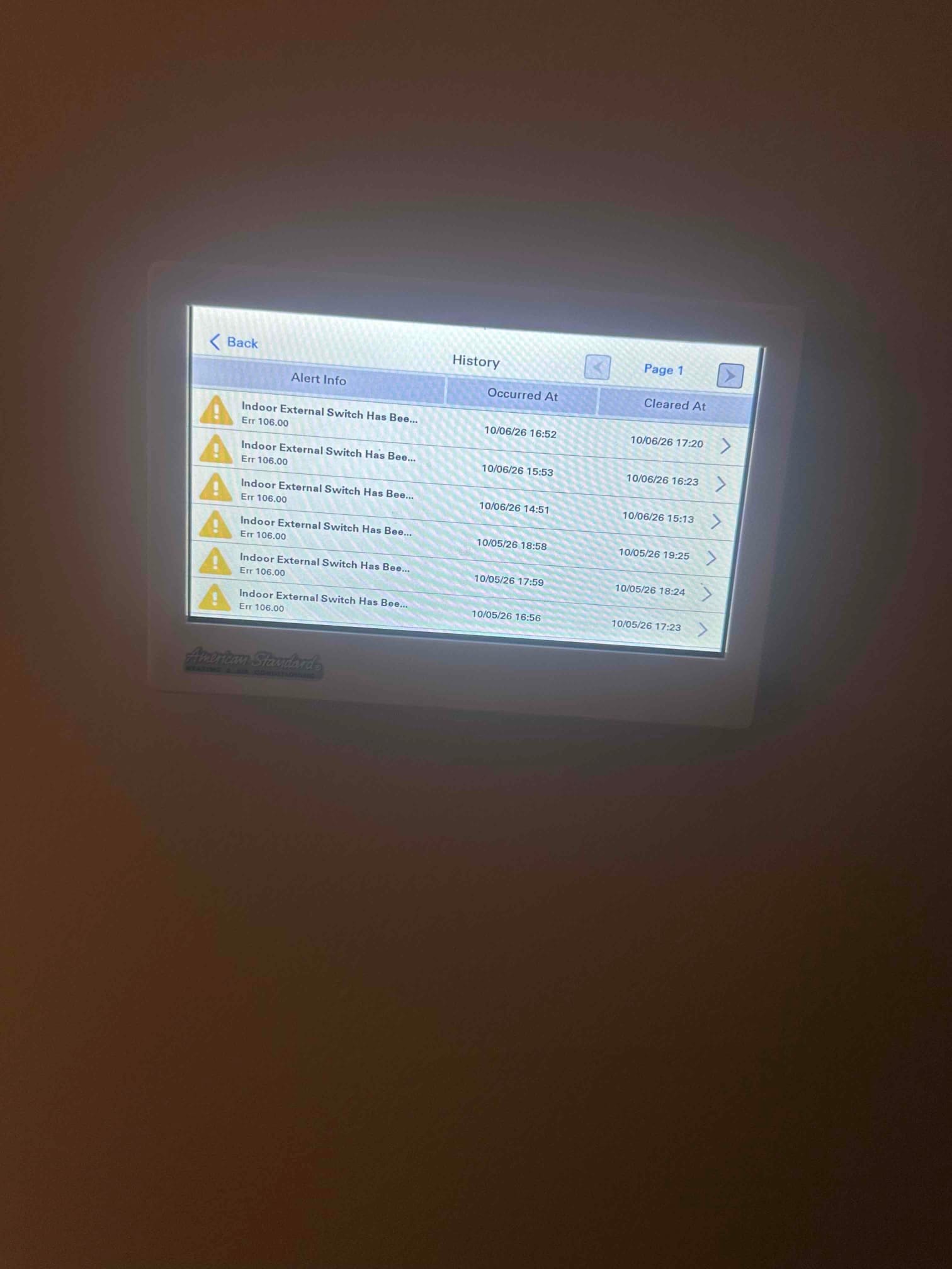 Thermostat touchscreen displays history list with multiple alerts labeled Indoor External Switch with error 106.00 timestamps.