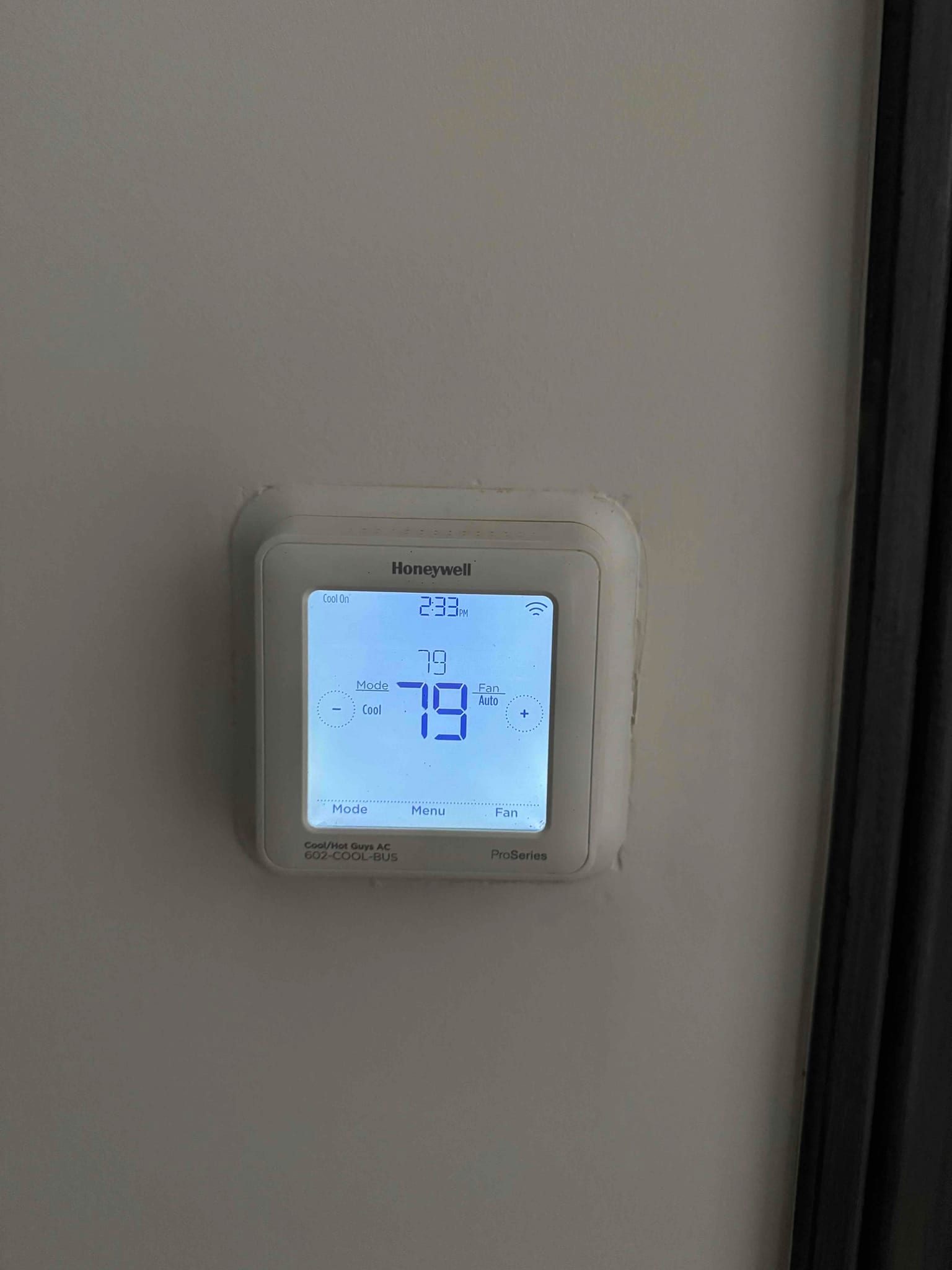 Wall-mounted thermostat with backlit display, showing Cool On status, Fan Auto, and a large 79 reading.