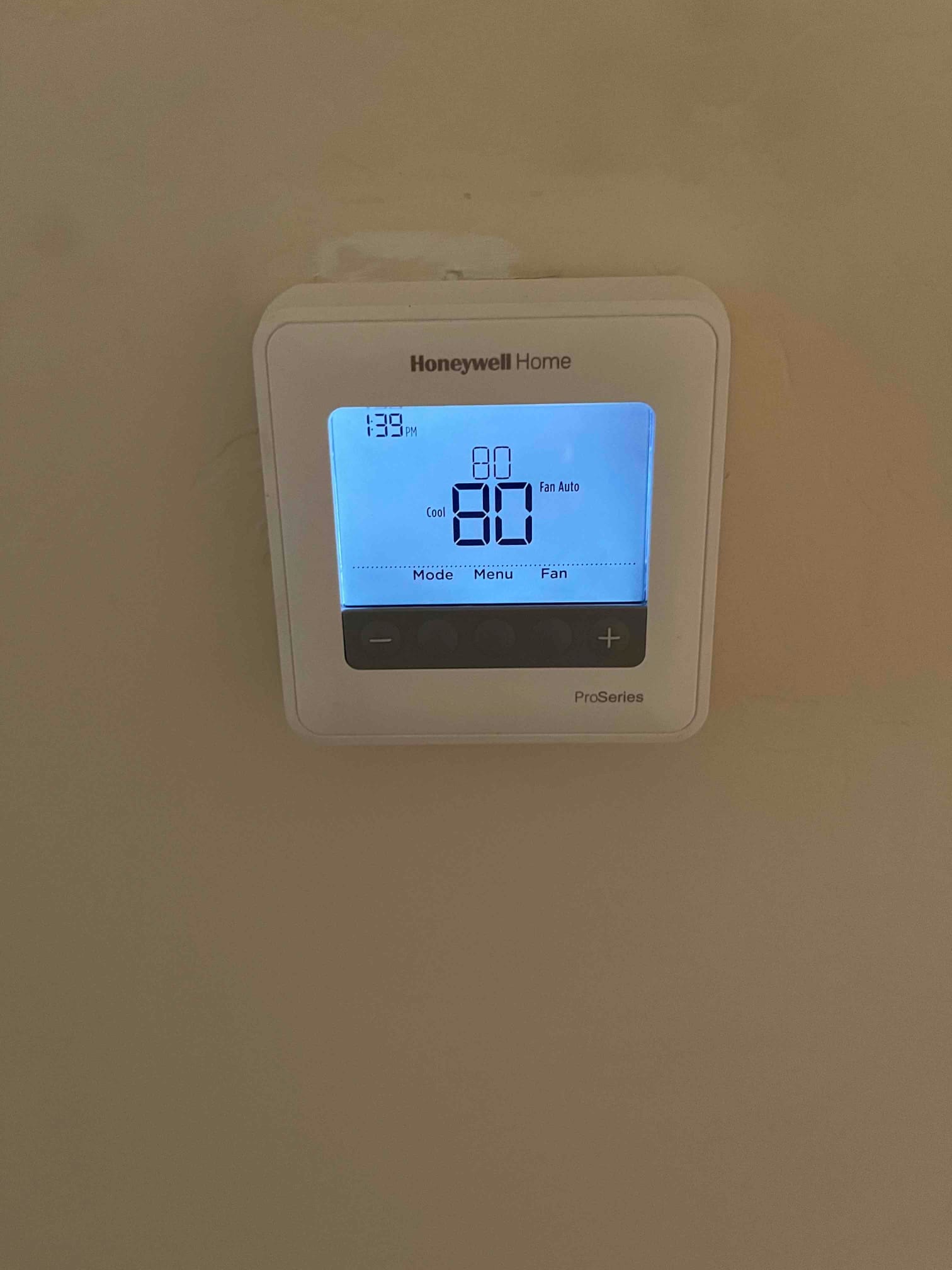 Wall-mounted thermostat display shows Cool mode with fan Auto and setpoint 80.
