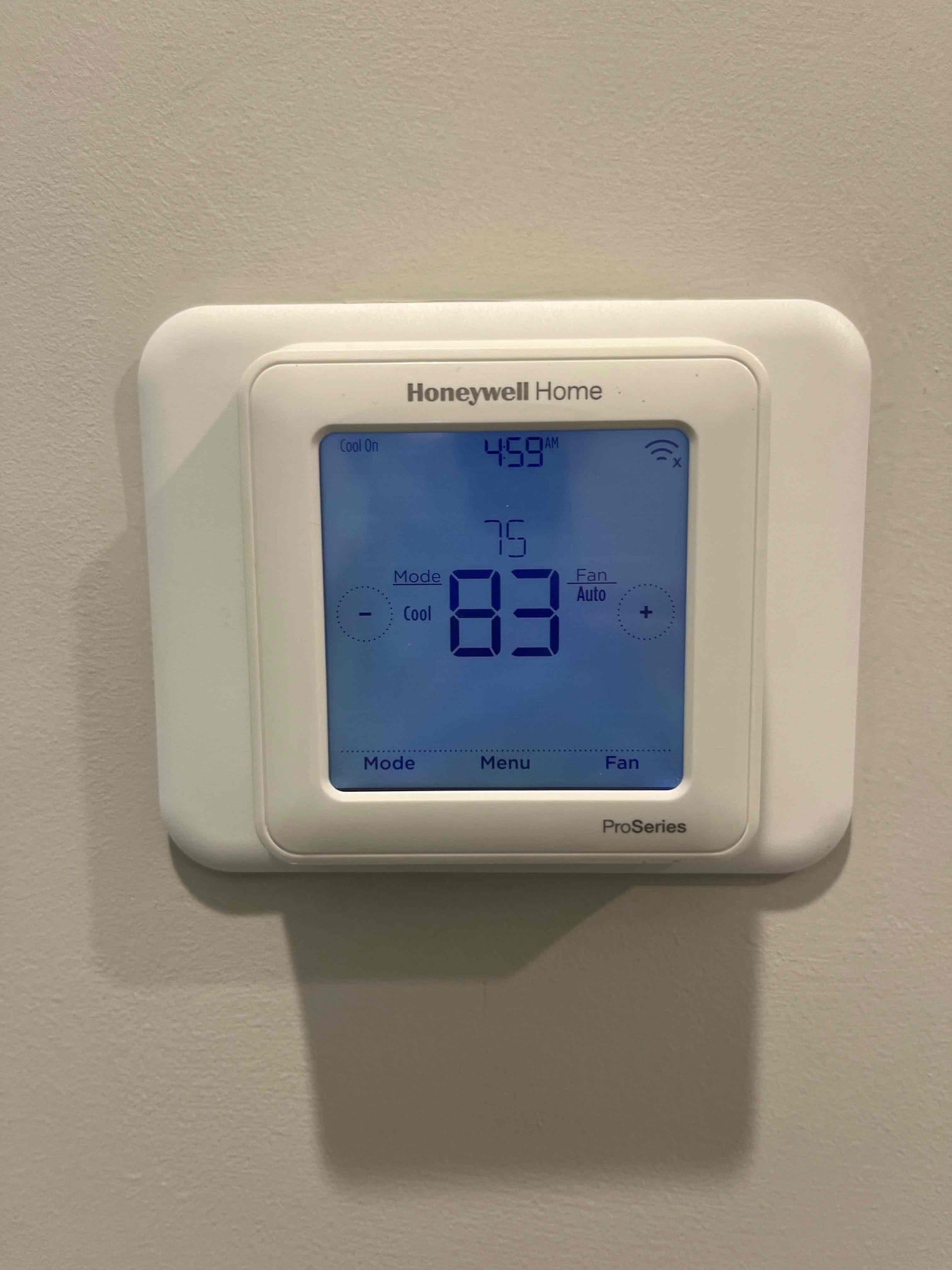 Wall-mounted thermostat displays cooling mode active with setpoint 83 and indoor temperature 75.