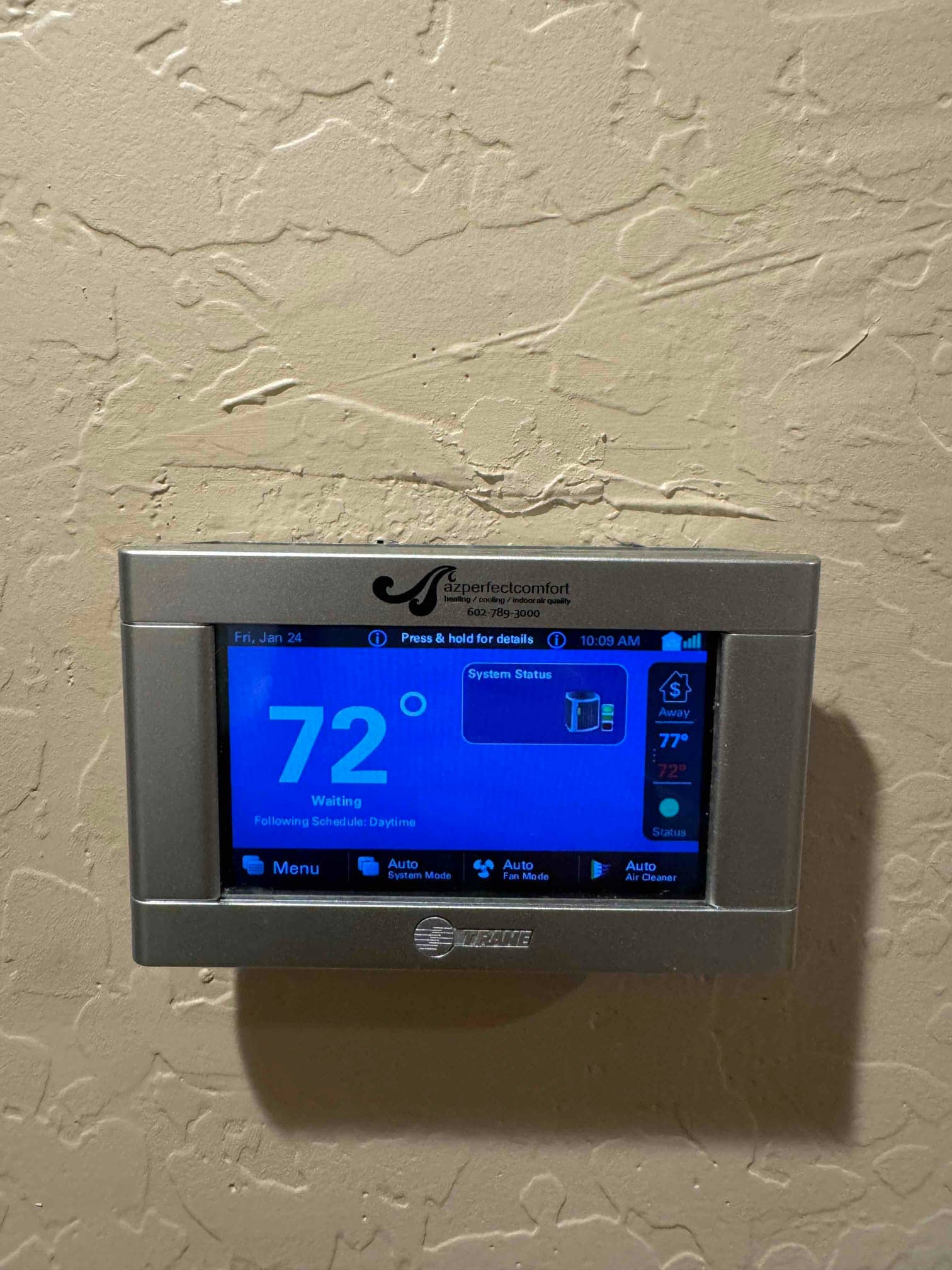 Wall-mounted touchscreen thermostat displays 72 degrees with system in waiting status and automatic modes selected.