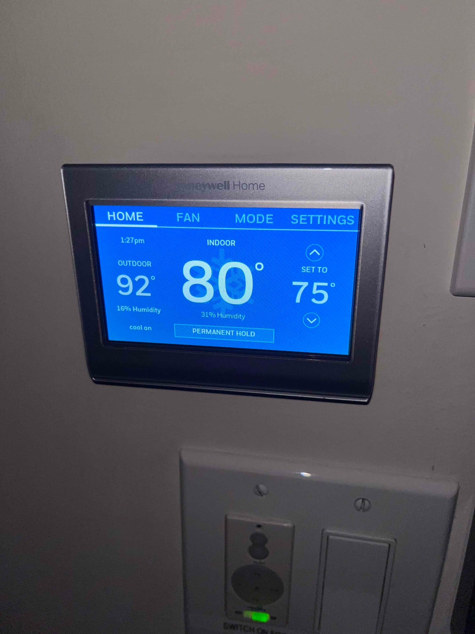Wall-mounted touchscreen thermostat displays indoor 80°F at 31% humidity, set to 75°F, with outdoor 92°F indicated.