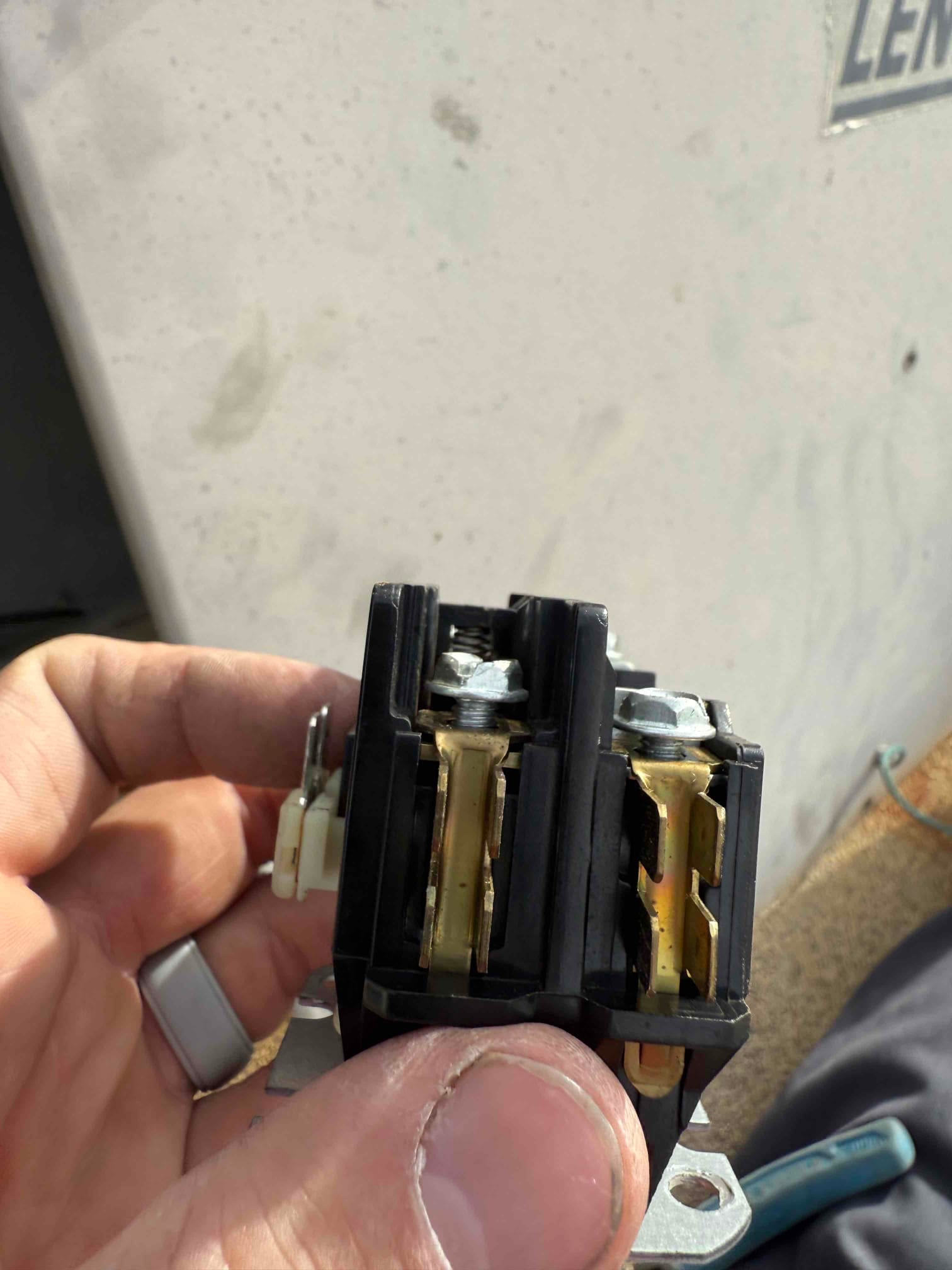 Two-pole contactor removed from outdoor unit, showing visible discoloration on the contact surfaces.