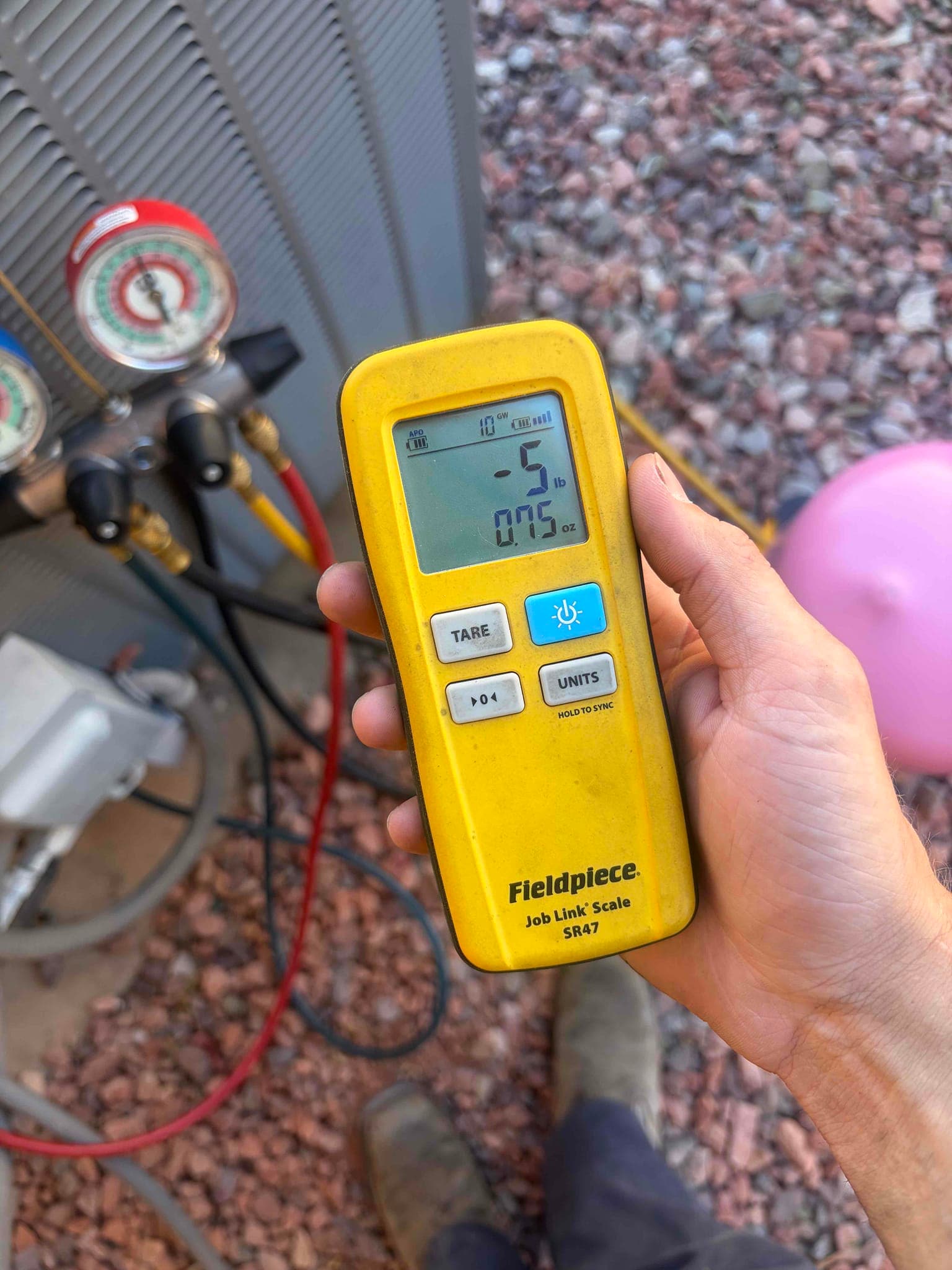 Refrigerant scale photographed during the service visit; no numerical reading is transcribed.