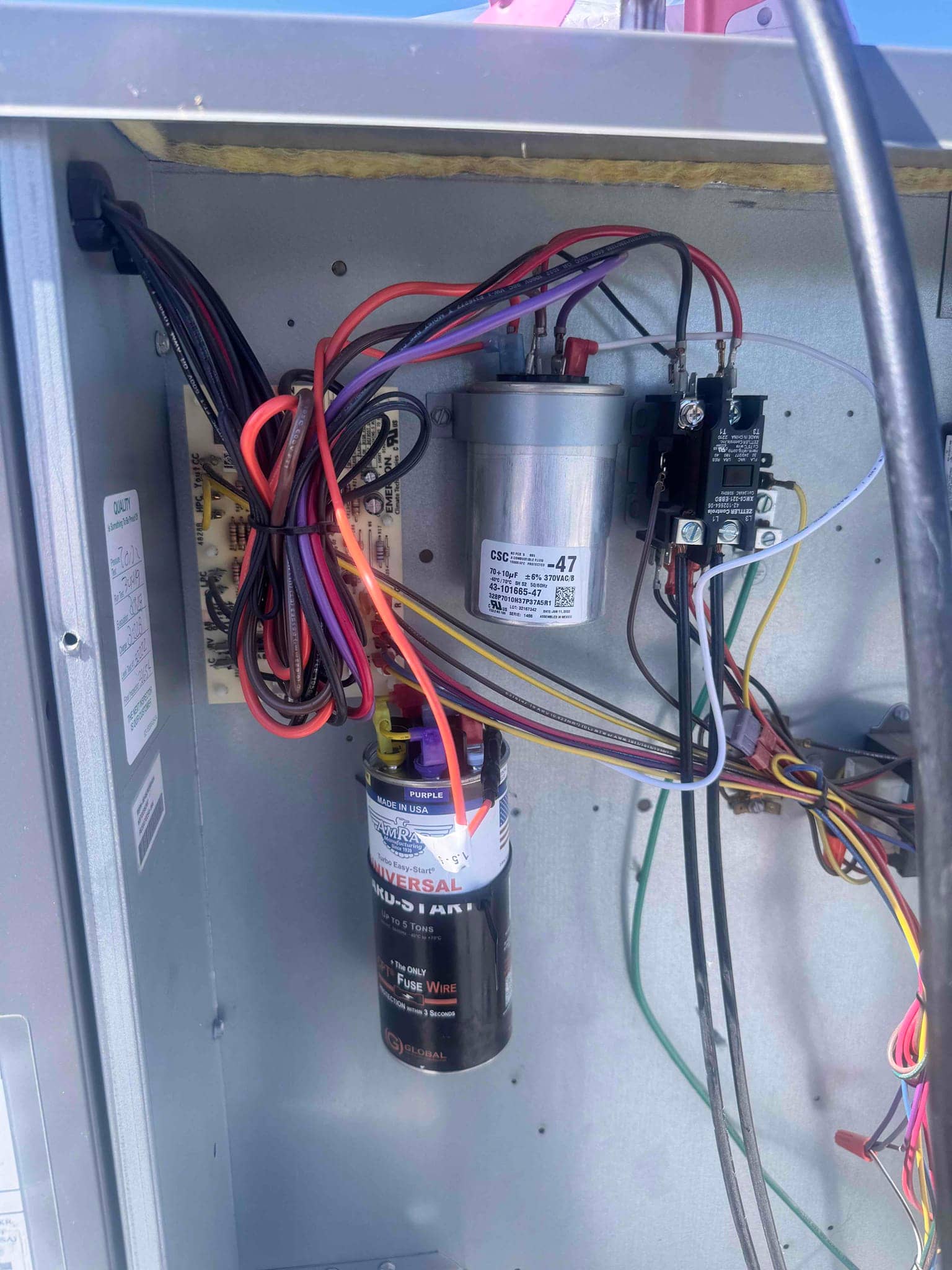 Condenser control compartment showing run capacitor, contactor, and hard-start kit with connected wiring harnesses.