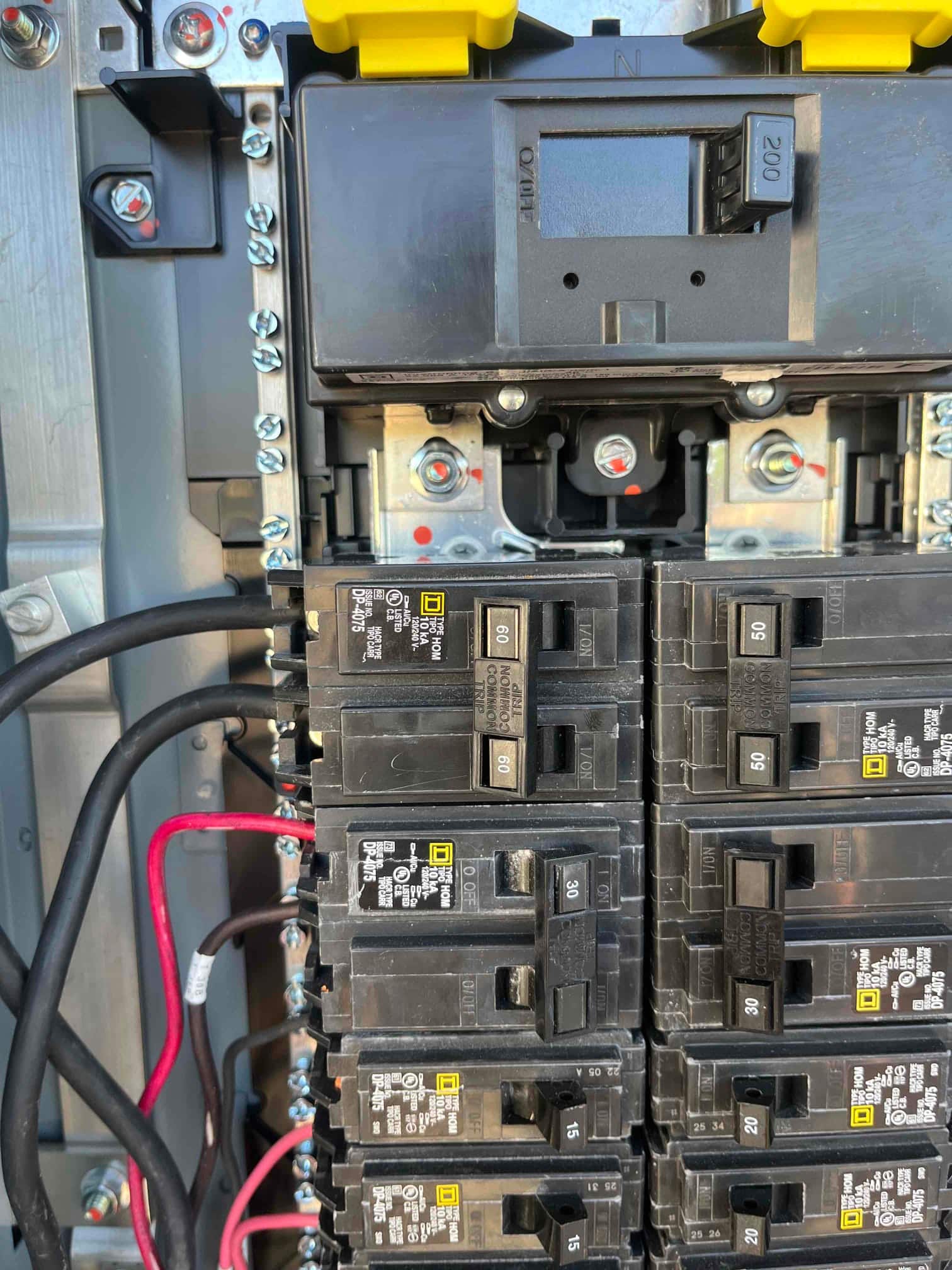 Multiple circuit breakers labeled 60 A, 50 A, 30 A, 20 A, and 15 A installed in an electrical service panel.