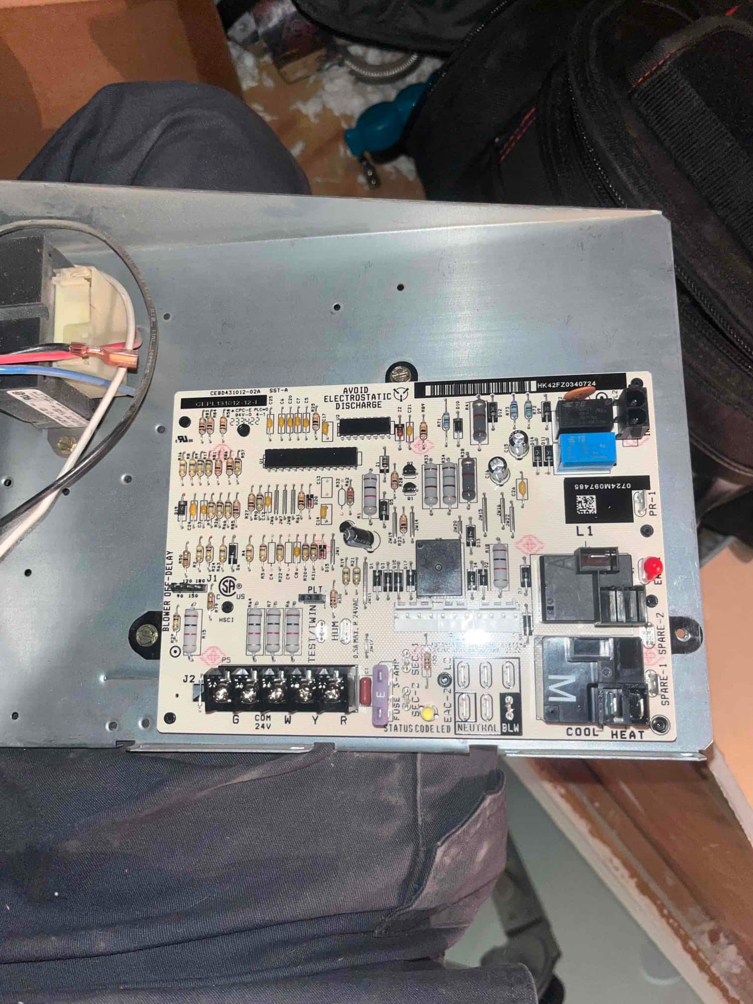 Furnace control board mounted on metal panel, showing terminal strip G W Y R and relays labeled COOL and HEAT.