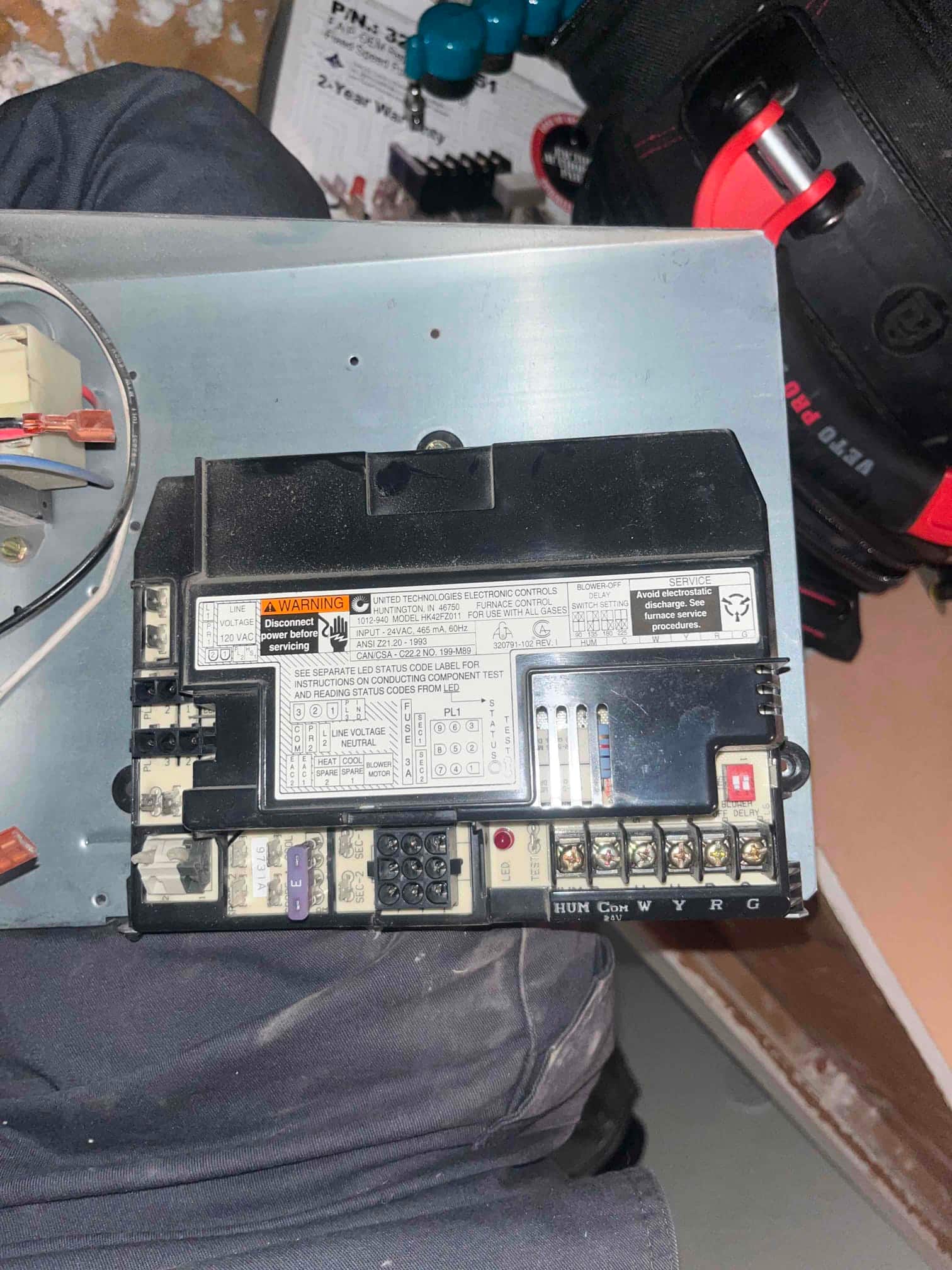 Furnace control board on mounting plate, showing labeled terminals W Y R G, DIP switches, fuse, and wiring connectors.