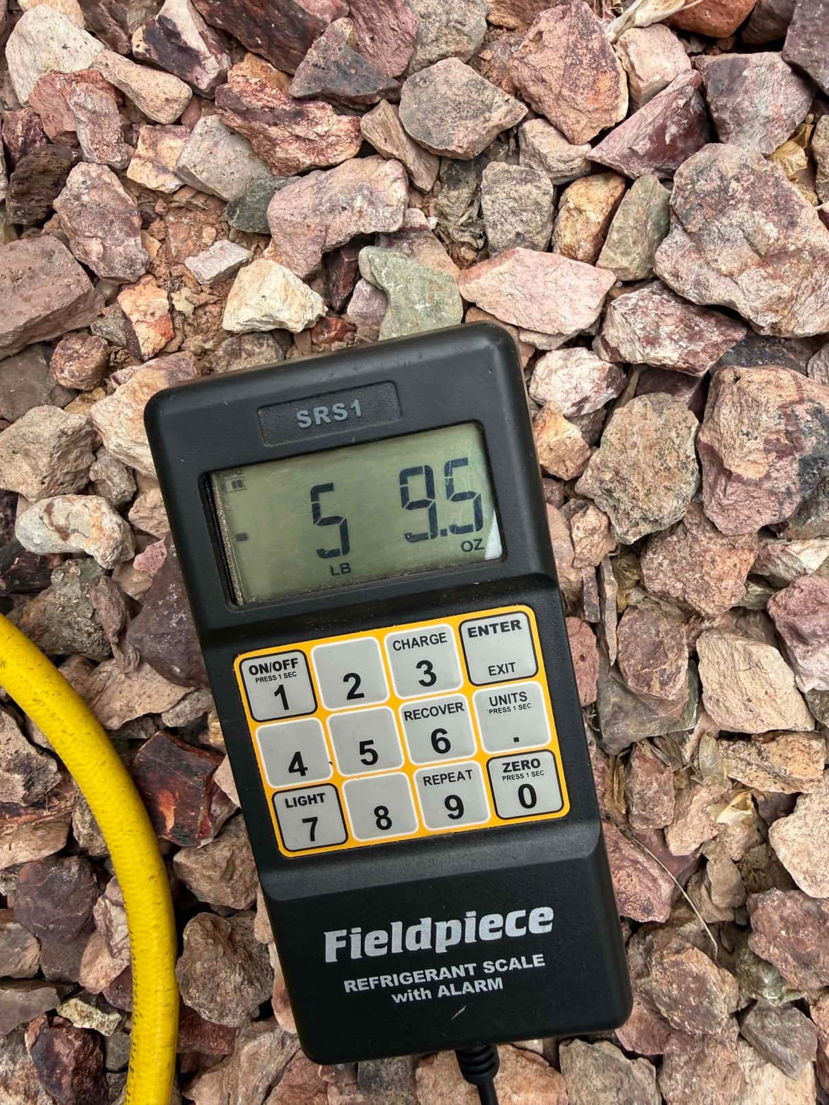 Refrigerant scale photographed during the service visit; no numerical reading is transcribed.