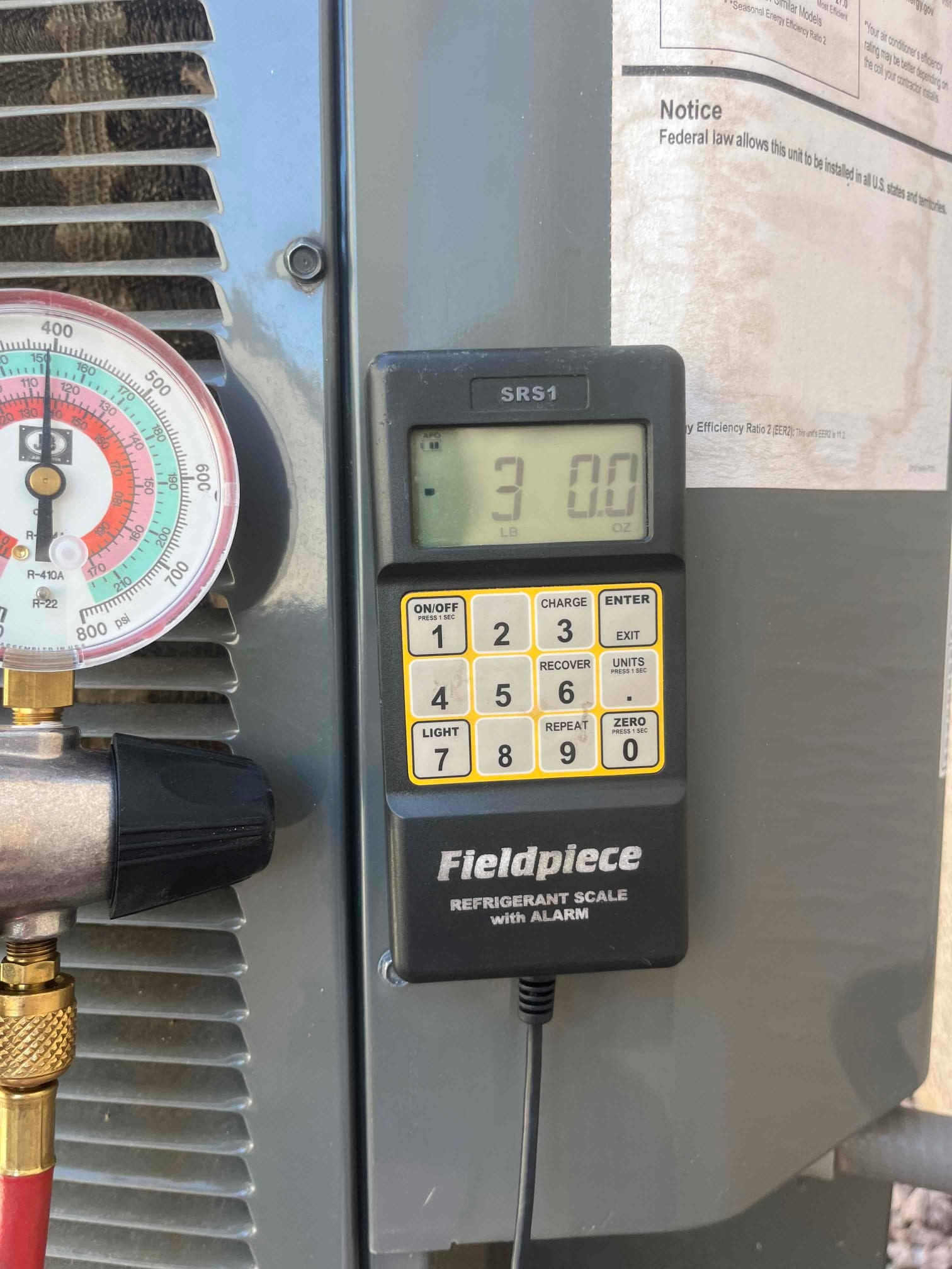 Refrigerant scale photographed during the service visit; no numerical reading is transcribed.