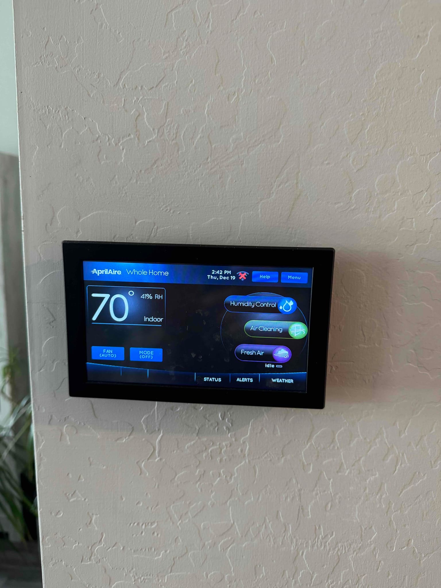 Wall-mounted touchscreen thermostat shows 70°F indoor temperature with 41% relative humidity and system status icons.